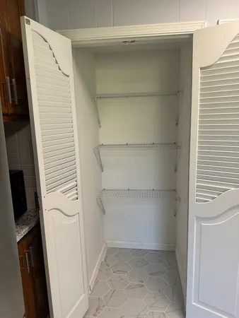 a view of walk in closet with empty racks