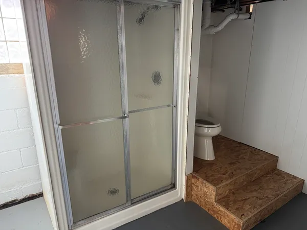 a bath room with a toilet and a shower