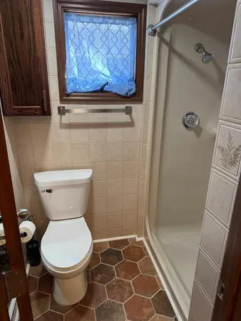 a bathroom with a toilet and a shower