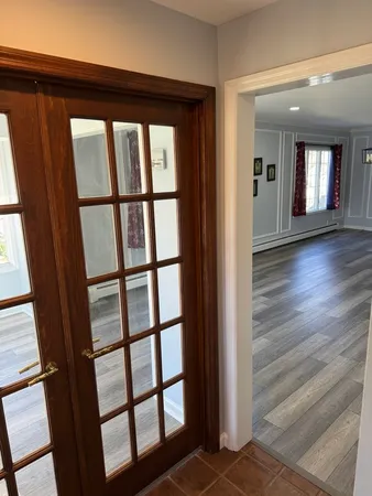 a view of a hallway with wooden floor and windows