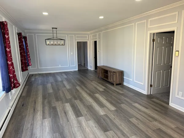 a view of a hallway with wooden floor and closet