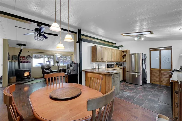 a kitchen with stainless steel appliances kitchen island granite countertop a table chairs and a refrigerator