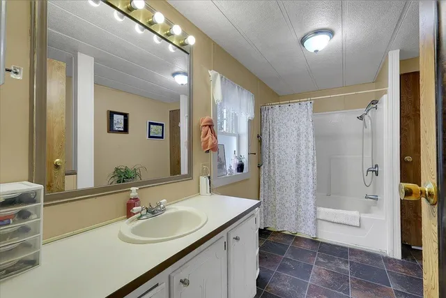 a bathroom with a double vanity sink mirror and shower