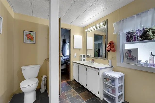 a spacious bathroom with a toilet sink and mirror