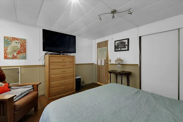 a bedroom with a bed and flat screen tv