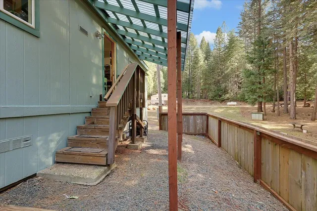 a view of a house with backyard and trees
