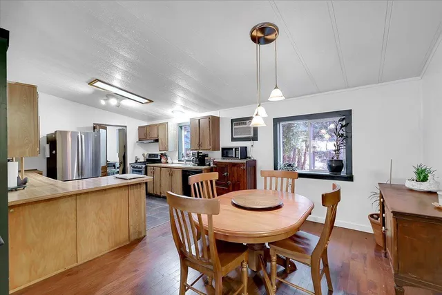a view of a dining room with furniture a chandelier and wooden floor