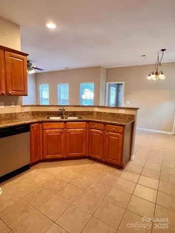 a large kitchen with granite countertop a stove sink and cabinets