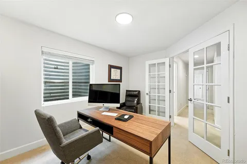 a view of a workspace with furniture and a window