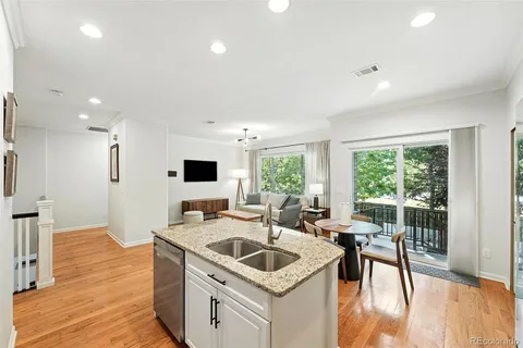 a kitchen that has a sink a table and chairs in it