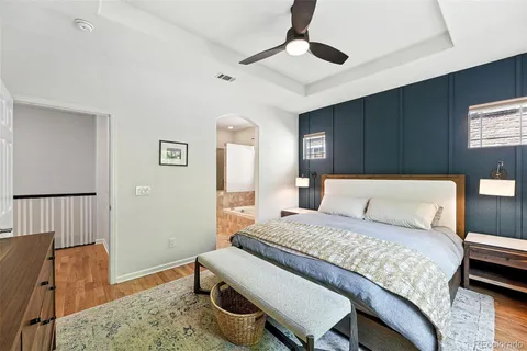 a bedroom with a bed a dresser and wooden floor