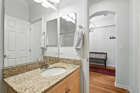 a bathroom with a granite countertop sink and a mirror