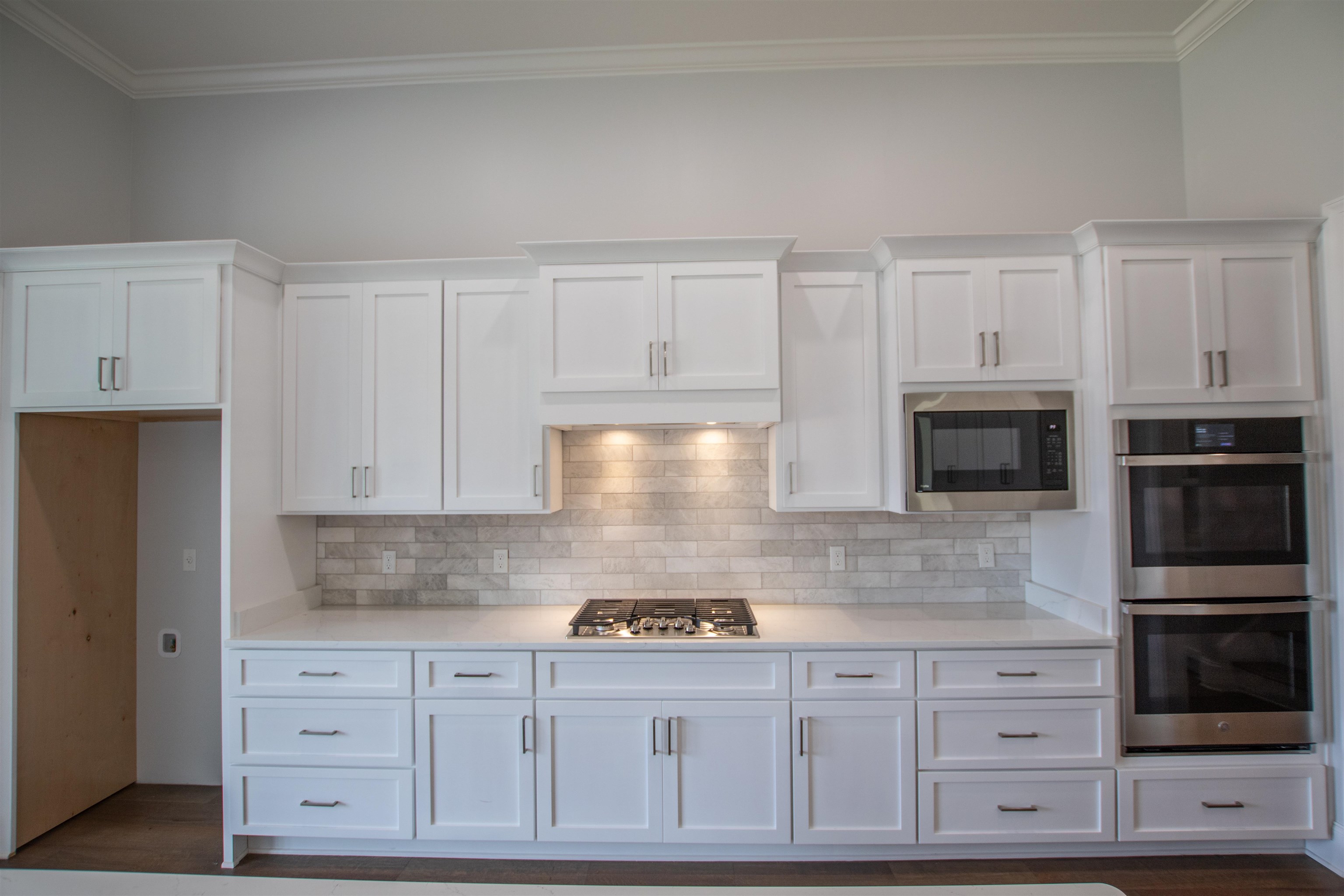 2611 Moore Road Germantown, TN 38138 - Photo 11 of 35 Kitchen with appliances with stainless steel finishes, white cabinets, dark hardwood / wood-style floors, and crown molding