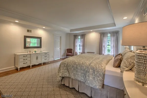 a spacious bedroom with a bed and a large mirror