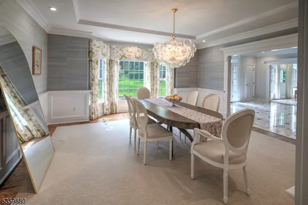 a dining room with furniture a chandelier and wooden floor