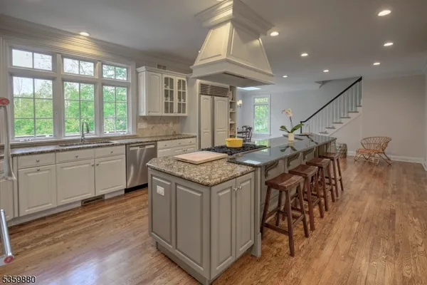 a open kitchen with stainless steel appliances granite countertop a stove and a wooden floors
