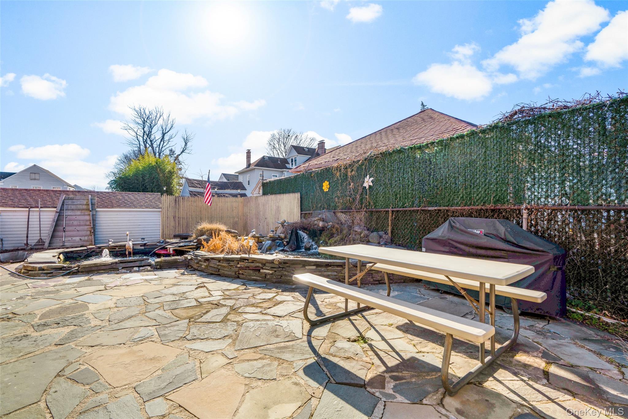 179 Drake Avenue, Unit 2J New Rochelle, NY 10805 - Photo 12 of 16 Fenced backyard with a patio area, a fire pit, koi pond, outdoor dining area, and area for grilling