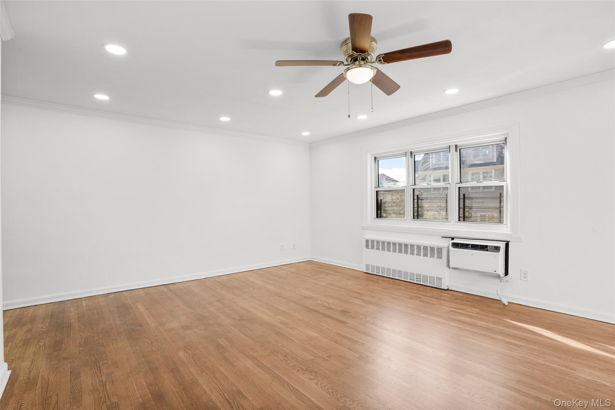 179 Drake Avenue, Unit 2J New Rochelle, NY 10805 - Photo 4 of 16 Living room with crown molding, radiator heating unit, light wood floors, a ceiling fan, and recessed lighting
