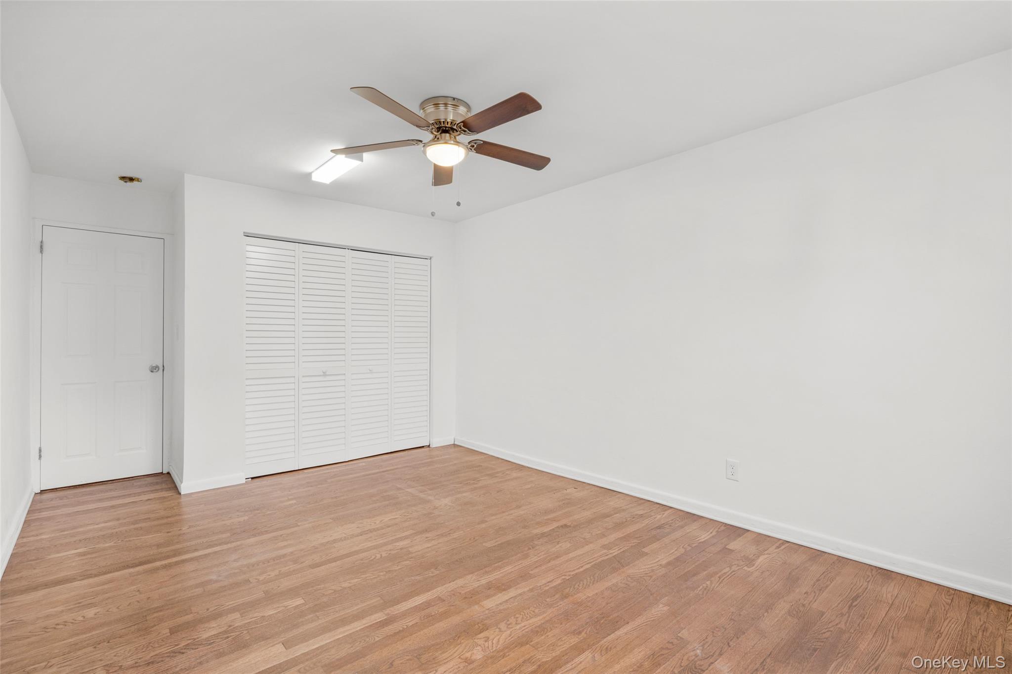 179 Drake Avenue, Unit 2J New Rochelle, NY 10805 - Photo 10 of 16 Unfurnished bedroom featuring light wood flooring, a ceiling fan, and a closet
