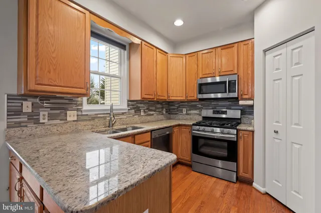 a kitchen with stainless steel appliances granite countertop a stove a sink and a microwave