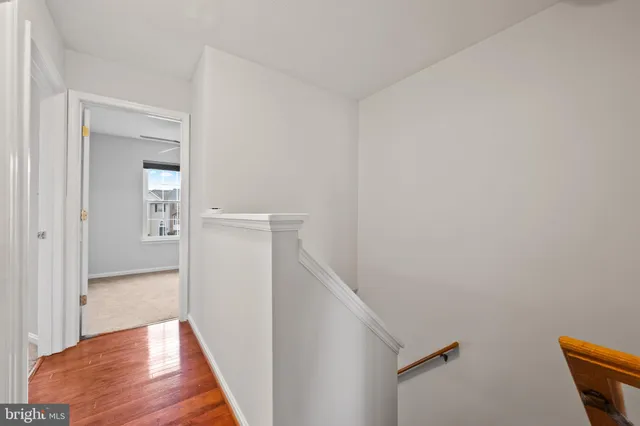 an empty room with chandelier fan and windows