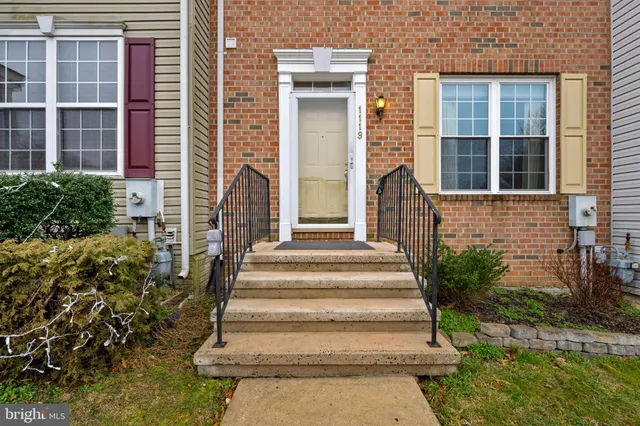 a view of a house with potted plants and a table and chairs