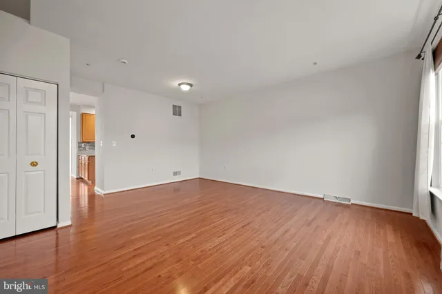 a view of an empty room with wooden floor