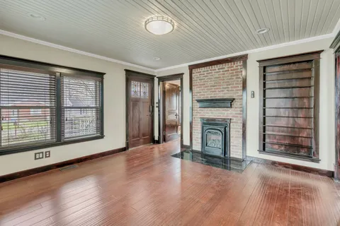 wooden floor fireplace and windows in an empty room