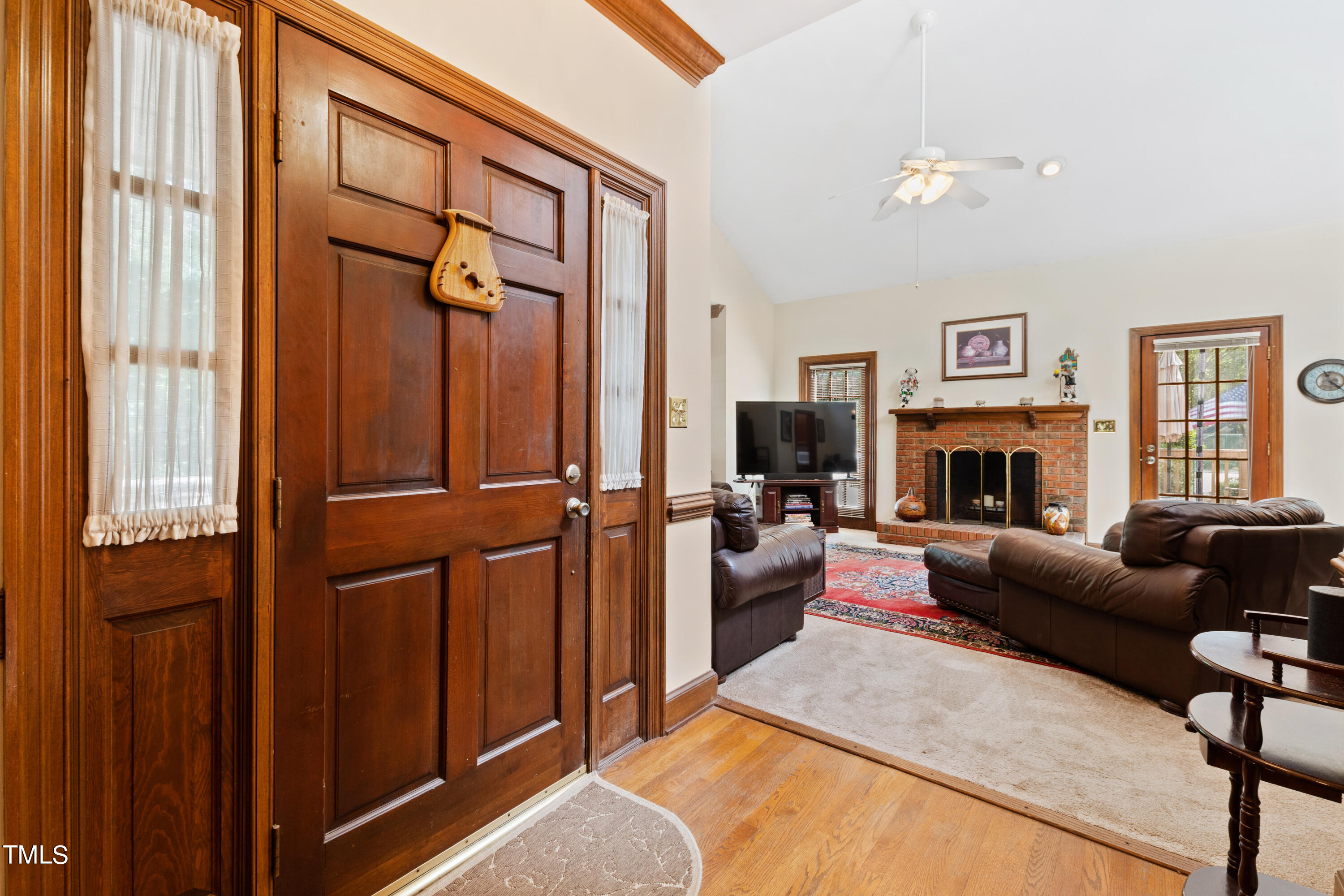 8450 Wycombe Lane Raleigh, NC 27615 - Photo 4 of 32 a living room with furniture a fireplace and a flat screen tv