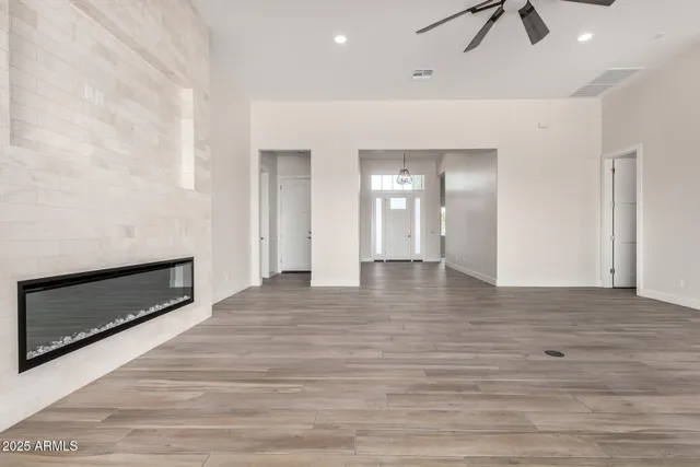 a view of a livingroom with a ceiling fan and wooden floor