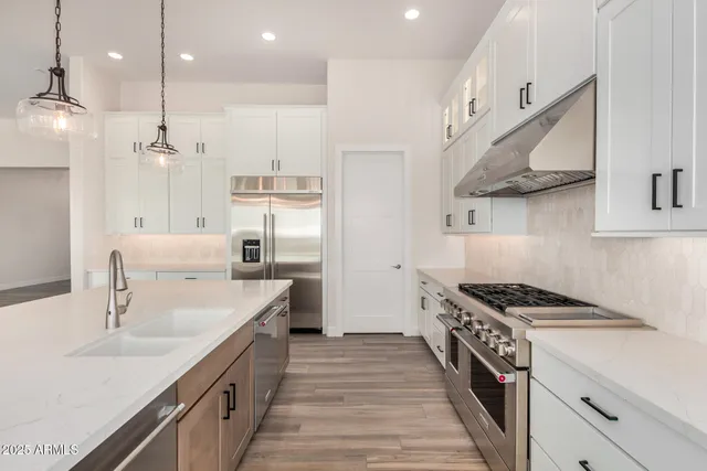 a kitchen with stainless steel appliances a sink stove and cabinets