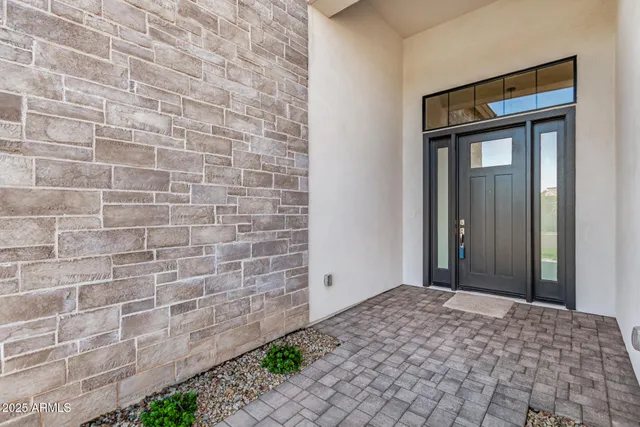 a view of an empty room with wooden floor and windows