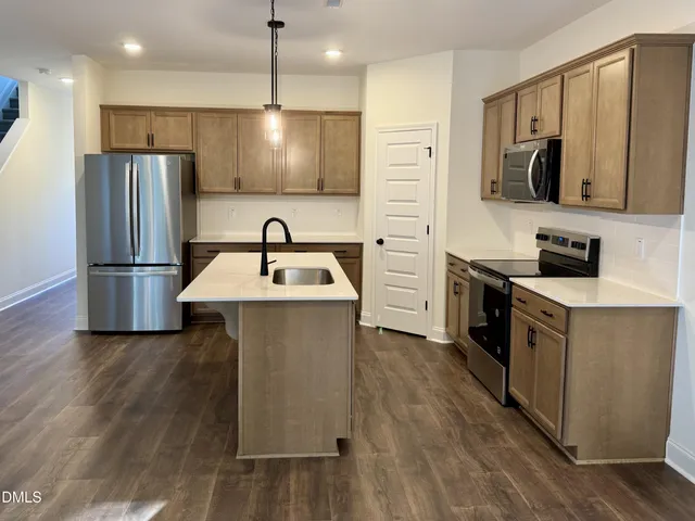 a kitchen with stainless steel appliances a refrigerator sink and microwave