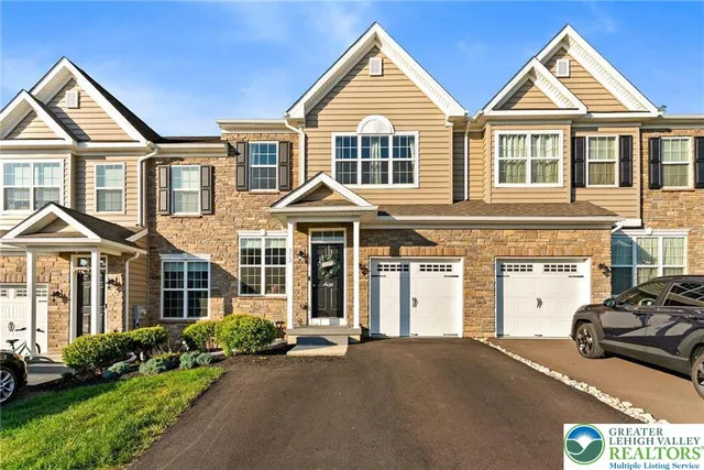 a view of a white house with a large windows and a yard