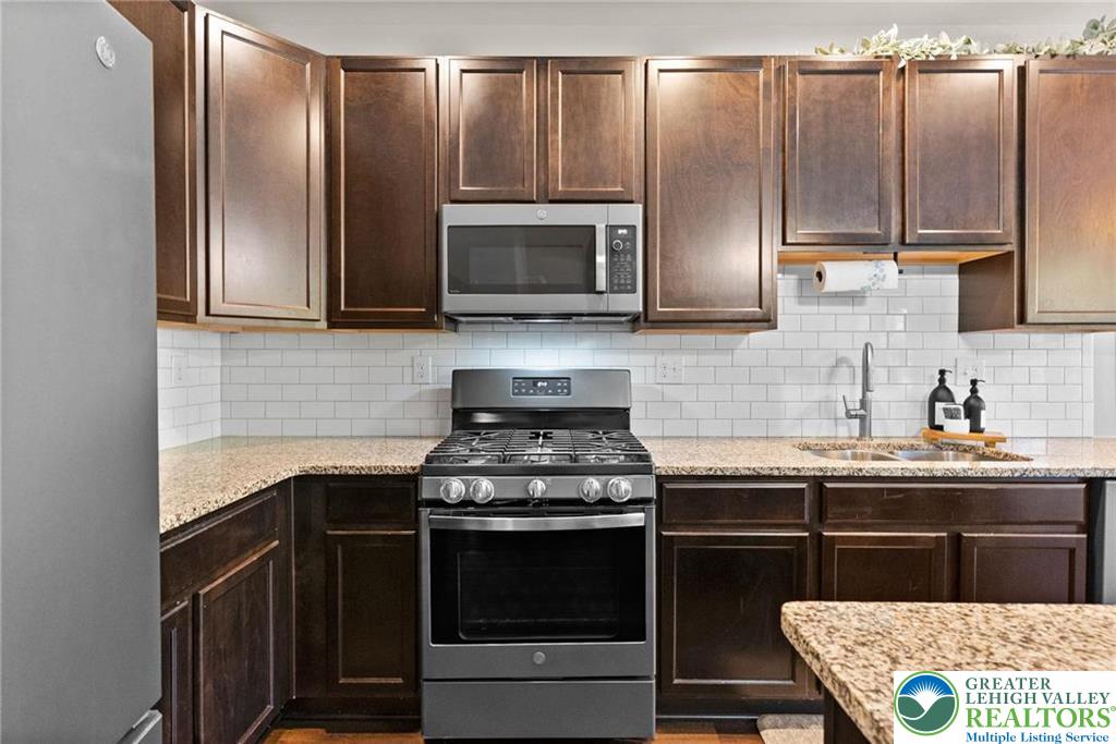 312 Redclover Lane Allentown, PA 18104 - Photo 13 of 60 a kitchen with stainless steel appliances granite countertop a stove a sink and a microwave