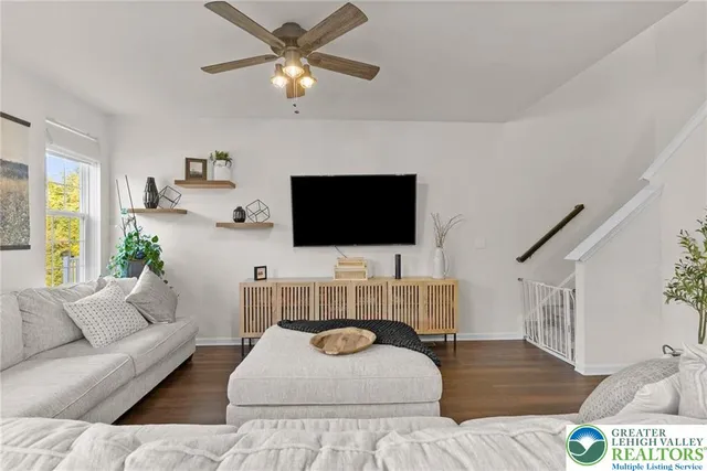 a living room with furniture kitchen and a wooden floor