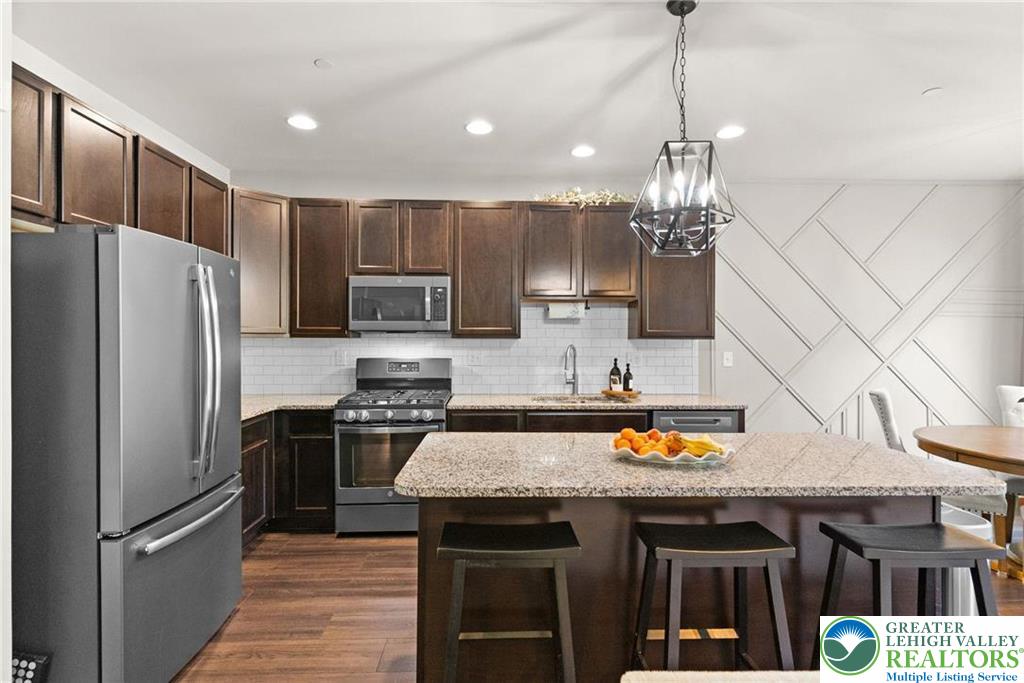 312 Redclover Lane Allentown, PA 18104 - Photo 10 of 60 a kitchen with stainless steel appliances granite countertop a refrigerator a sink dishwasher a stove and a wooden floor