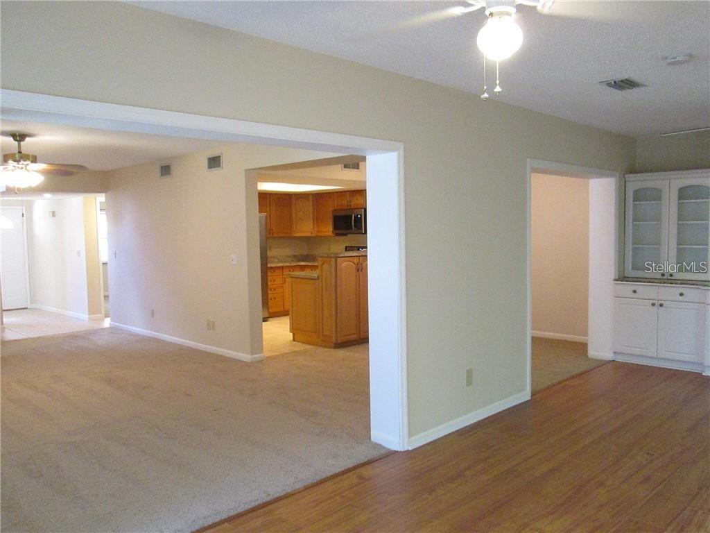 14873 Feather Cove Road Clearwater, FL 33762 - Photo 6 of 25 an empty room with wooden floor and cabinet