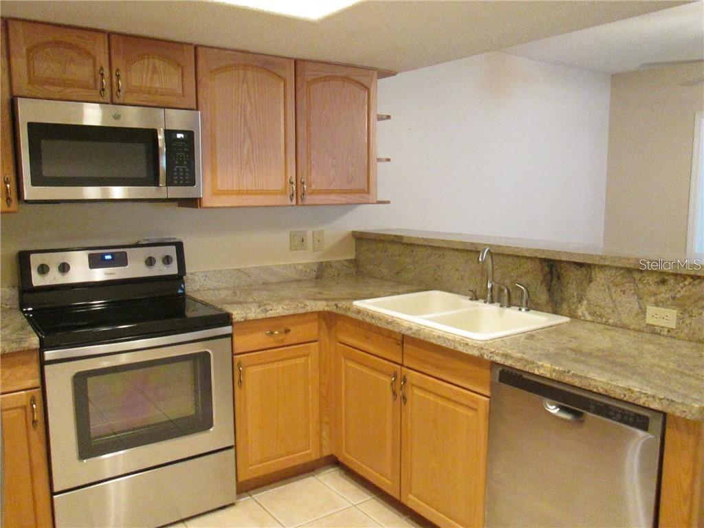 14873 Feather Cove Road Clearwater, FL 33762 - Photo 9 of 25 a kitchen with a sink stove and microwave