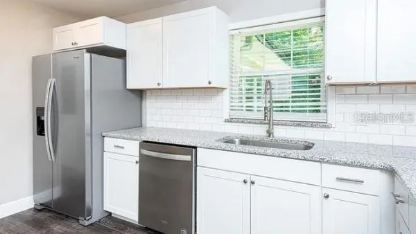 a kitchen with stainless steel appliances granite countertop a refrigerator and a sink