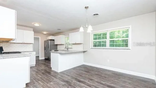a kitchen with a sink wooden floor cabinets and a window