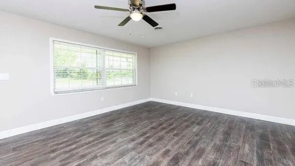 wooden floor in an empty room with a window