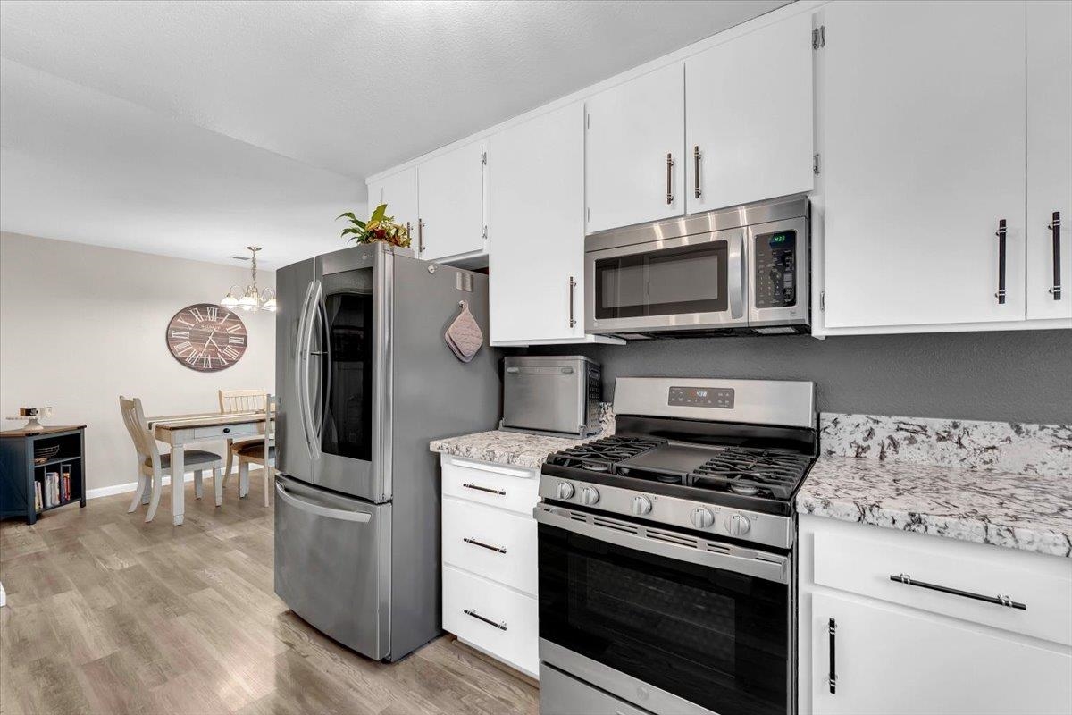 2110 Gentry Way Red Bluff, CA 96080 - Photo 13 of 47 a kitchen with stainless steel appliances granite countertop a stove a microwave and a refrigerator