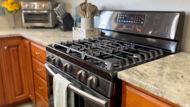 1797 Sunset Road Enoch, UT 84721 - Photo 13 of 80 Stainless steel range with a gas cooktop and digital display, set into a stone-finish countertop