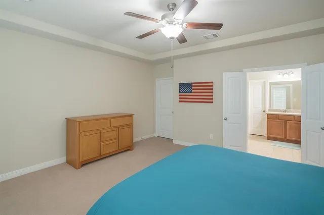 a view of an empty room with chandelier fan and a window