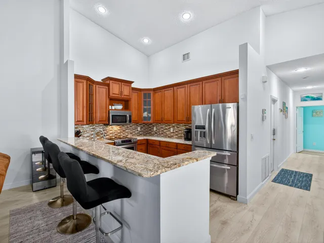 a kitchen with stainless steel appliances granite countertop a stove refrigerator and a sink