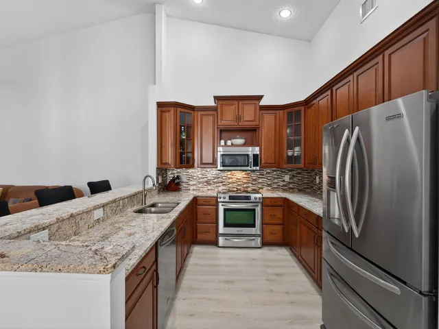 a kitchen with stainless steel appliances granite countertop a sink stove and refrigerator