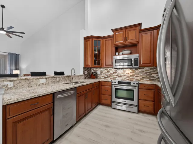 a kitchen with stainless steel appliances granite countertop a sink stove and refrigerator