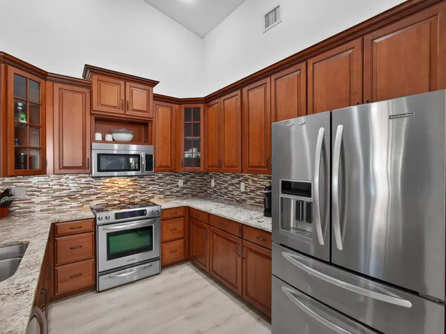 a kitchen with stainless steel appliances granite countertop a refrigerator stove and oven