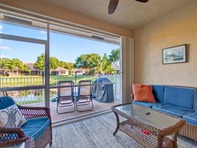 a living room with furniture and a floor to ceiling window